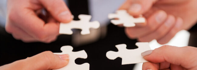 Close-up of many people holding puzzle elements close to each other
