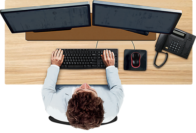 overhead view of man working at desk with computer keyboard, monitors, mouse and phone in easy reach