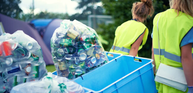 Cropped shot of two young women picking up trash after an event