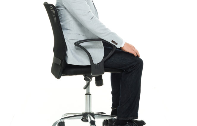 Cropped side view of business person sitting in adjustable desk chair from shoulders to feet