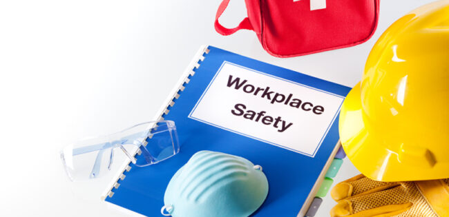 Still life of a handbook manual for workplace safety and various safety equipment.