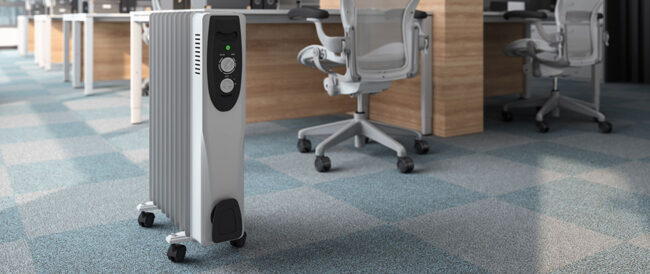 Silver tower space heater in an empty shared office.