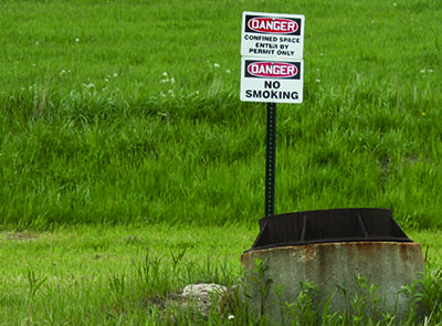 Danger signs warn of confined space near underground work zone entry