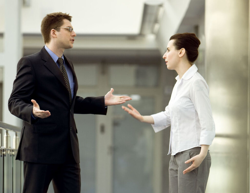 Verbal argument between two business people in the workplace.
