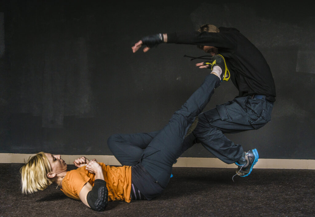 Woman practices self-defense moves with man