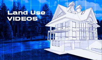 Blue line drawing of two-story home set near a lake and woods