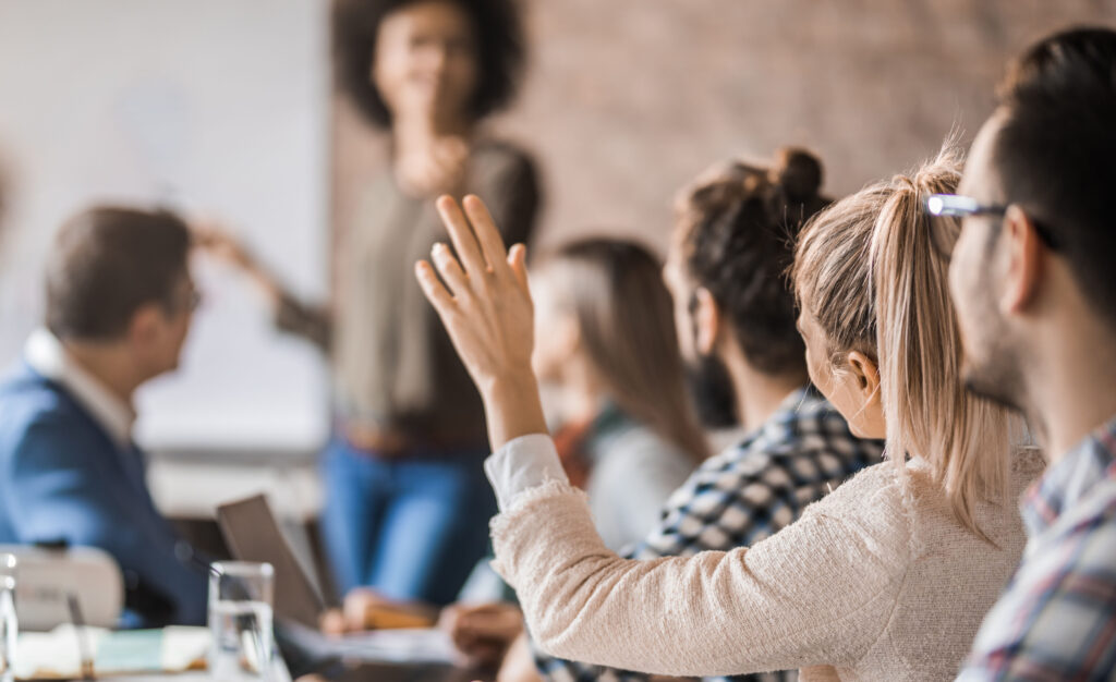 Female asks a question in a meeting in the office.