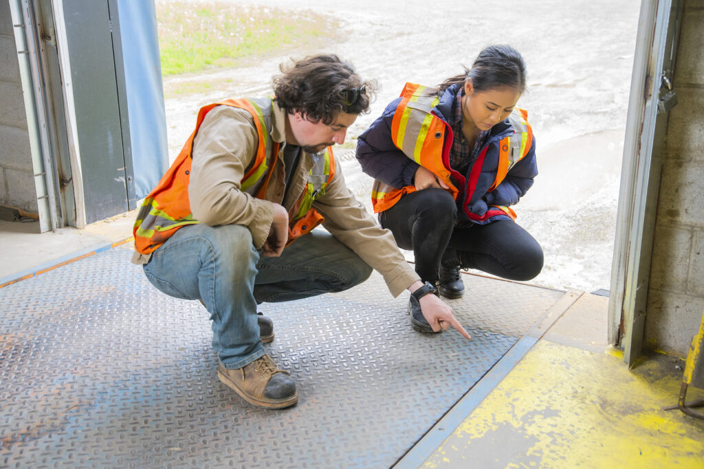 A supervisor or manager explains the danger involved with lifting and dropping loading dock plates.