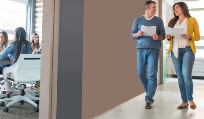 Co-workers walking down office hallway that is free of clutter and tripping hazards.