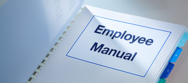 Employee manual open to title page, shows tabs for sections