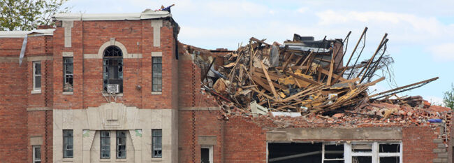 Red brick building with chunk of second floor destroyed. Presumably from tornado damage.