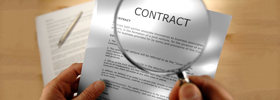 Person reading a contract with a magnifying glass over the title 