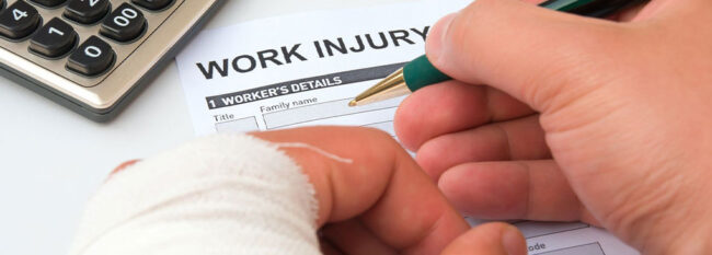 Person filling out "Work Injury" form. Left hand is wrapped in gauze.
