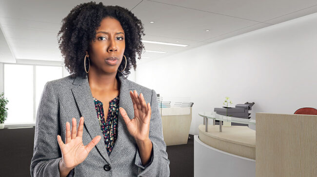 Businesswoman in an office looking scared with hands in calm down gesture.