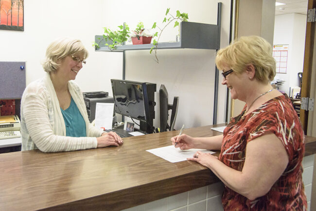 County employee assists citizen at service desk.