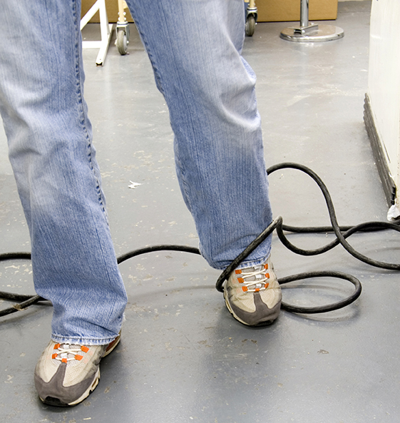 Man tangles foot in electric cord crossing the walkway, electrical cords, slip, trip