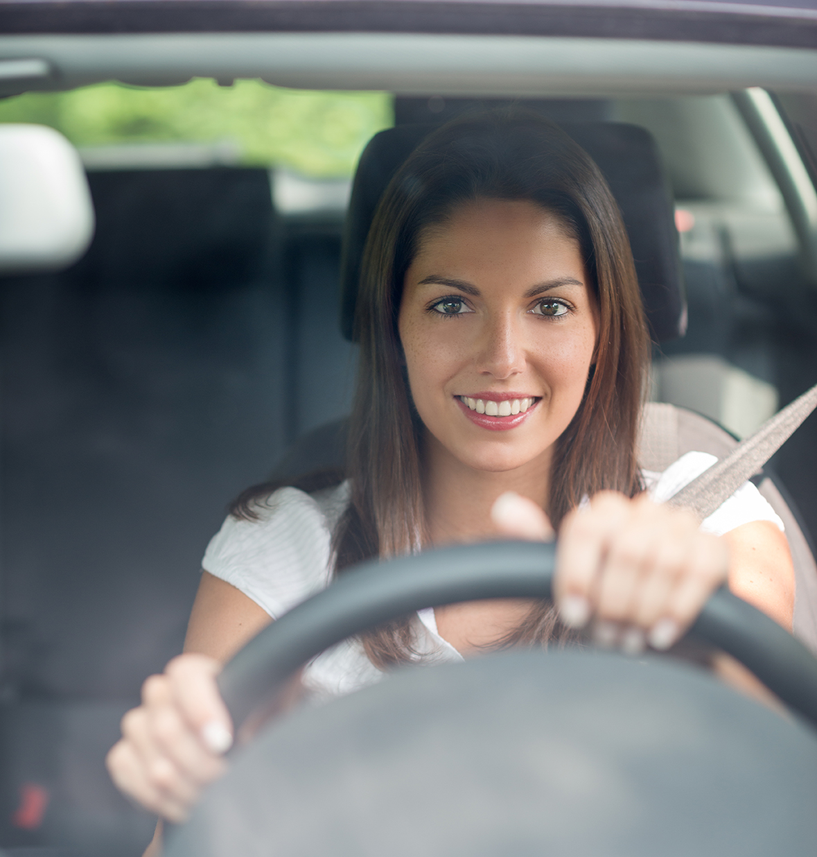 Woman driving wearing a seat belt.