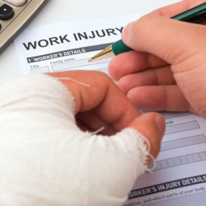 Close up of hand in cast and other hand completing a Work Injury form
