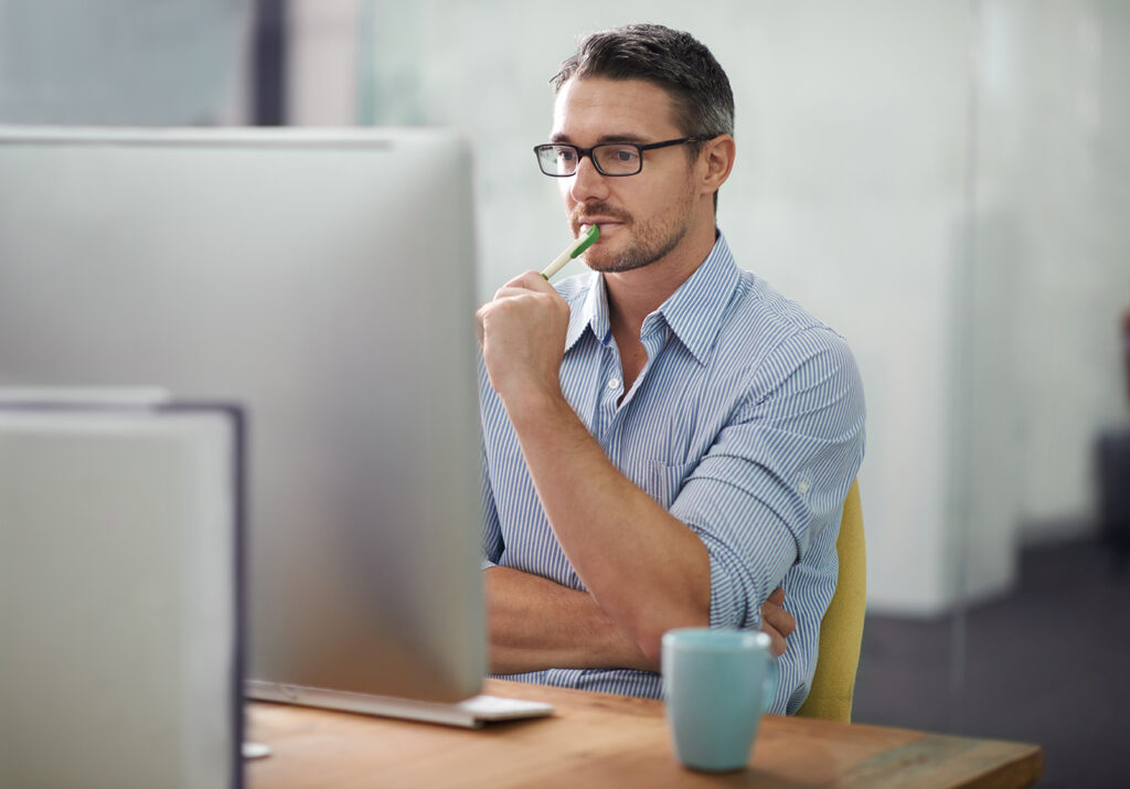 A cropped shot of a businessman thinking while working at his desk