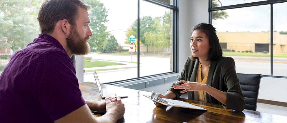 Business woman has one-on-one conversation with employee in office