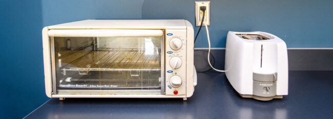 Toaster oven and toaster in breakroom.