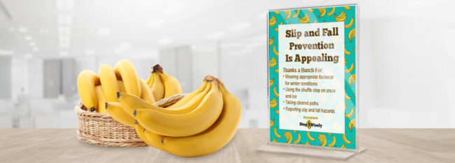 Bananas in a basket on an office table. Sign with a banana pattern reads "Slip and Fall Prevention Is Appealing".