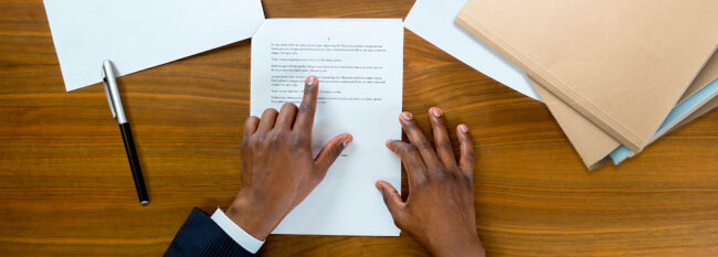 Man reviewing contract. Hands only view.