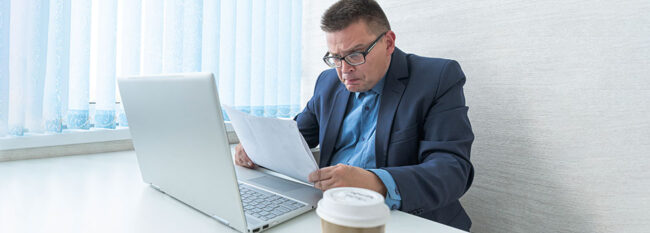 Man reading contract and looking surprised or angry.