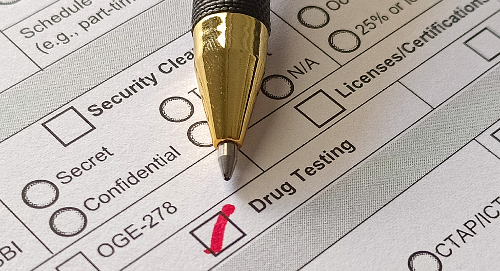 Pen lies on form with "drug testing" checked