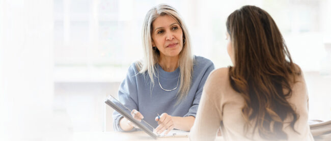 Female business woman talks with an employee against a blurred background