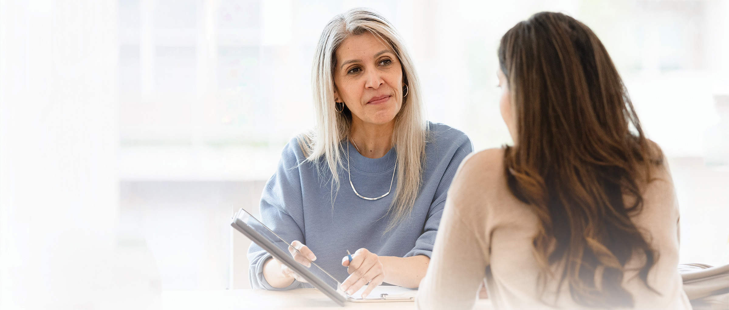 Female business woman talks with an employee against a blurred background